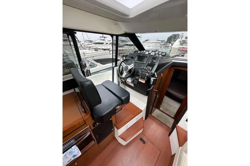  Yacht Photos Pics 2015 Jeanneau NC11 boat interior with helm, steering wheel, and control panel.