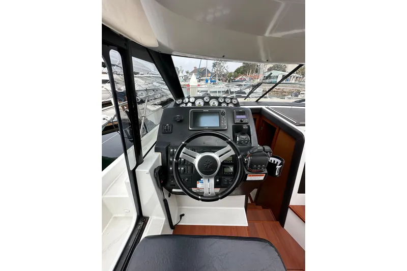  Yacht Photos Pics Helm of 2015 Jeanneau NC11 boat with steering wheel and navigation controls.