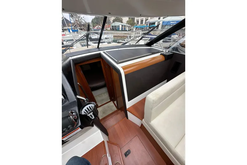  Yacht Photos Pics Interior view of 2015 Jeanneau NC11 boat, featuring helm and seating area.