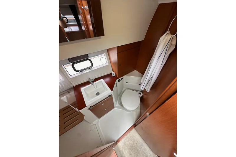  Yacht Photos Pics 2015 Jeanneau NC11 bathroom interior with sink, toilet, and wooden accents.