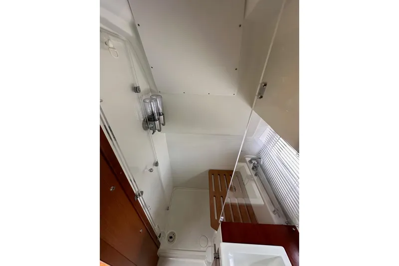  Yacht Photos Pics 2015 Jeanneau NC11 yacht bathroom with shower, wooden accents, and modern fixtures.