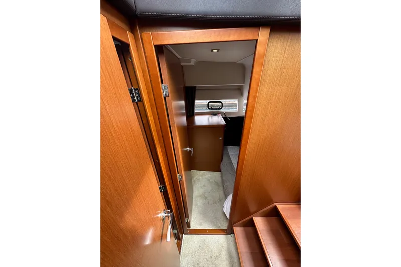  Yacht Photos Pics Interior view of 2015 Jeanneau NC11 boat cabin with wooden finish.