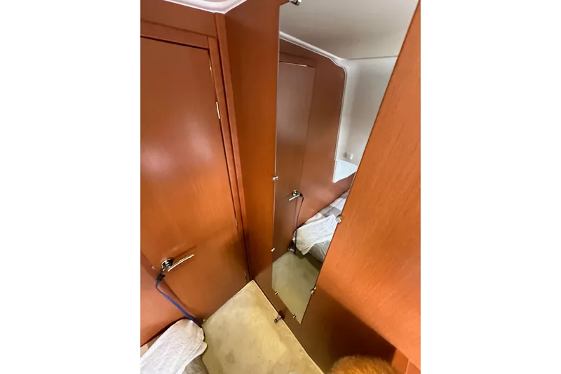  Yacht Photos Pics Interior of 2015 Jeanneau NC11 boat with wooden doors and cozy cabin space.