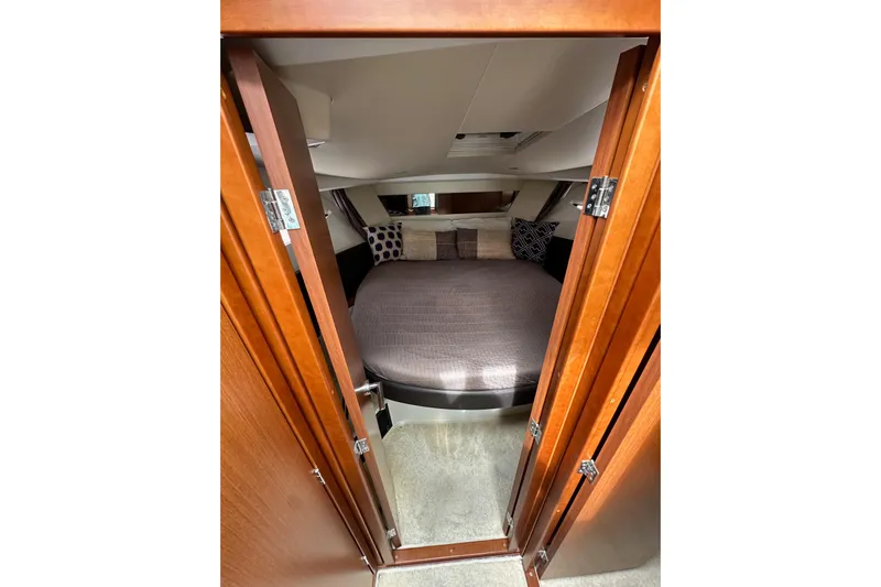  Yacht Photos Pics Cozy cabin interior of 2015 Jeanneau NC11 with plush bedding and wooden accents.