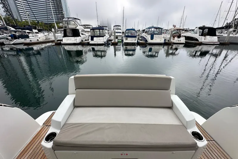  Yacht Photos Pics 2015 Jeanneau NC11 boat with seating, docked in a marina with other yachts.