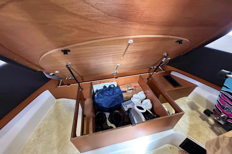  Yacht Photos Pics Storage compartment in a 2015 Jeanneau NC11 boat, containing various items and equipment.