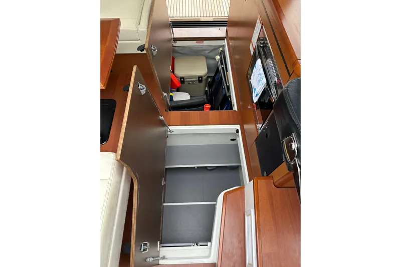  Yacht Photos Pics 2015 Jeanneau NC11 interior storage compartments with wooden finish and open hatches.