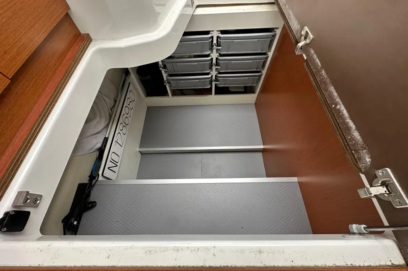  Yacht Photos Pics Storage compartment in a 2015 Jeanneau NC11 boat with organized bins and equipment.