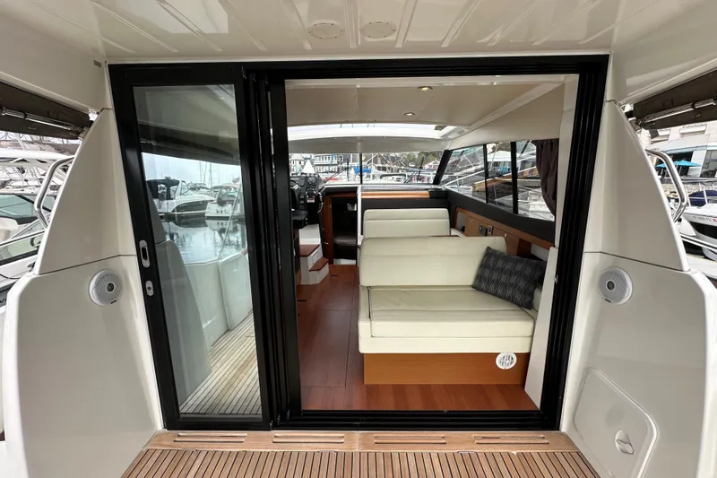  Yacht Photos Pics 2015 Jeanneau NC11 yacht interior with sliding glass doors and comfortable seating.