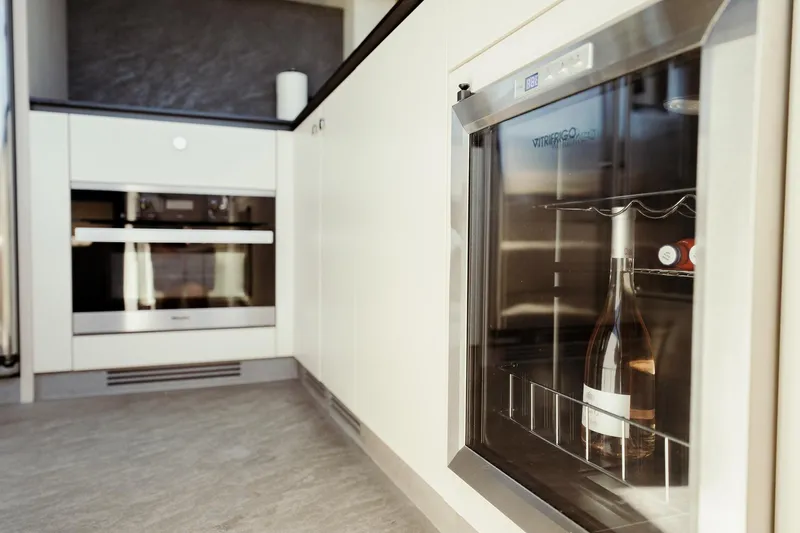 Transcendence Yacht Photos Pics Modern kitchen interior on Azimut 78 Flybridge yacht, featuring a wine cooler and oven.
