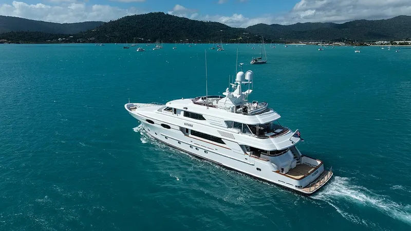  Yacht Photos Pics Luxurious 2003 Sovereign Tri-Deck yacht cruising in turquoise waters with scenic mountain backdrop.