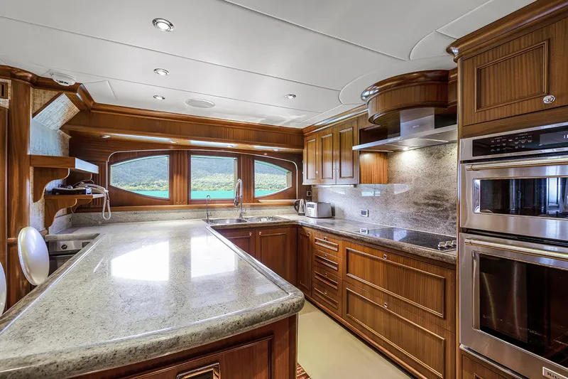  Yacht Photos Pics Luxurious kitchen in 2003 Sovereign Tri-Deck yacht with modern appliances and elegant wood cabinetry.