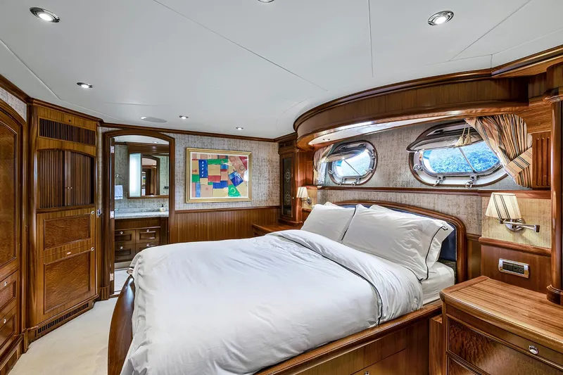  Yacht Photos Pics Luxurious Sovereign Tri-Deck 2003 yacht bedroom with elegant wood finishes and porthole windows.