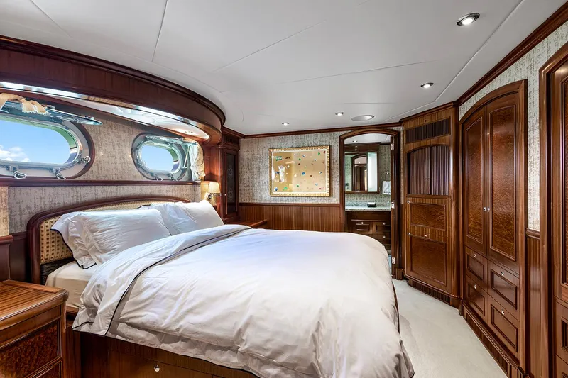  Yacht Photos Pics Luxurious Sovereign Tri-Deck 2003 yacht bedroom with elegant wood paneling and plush bedding.
