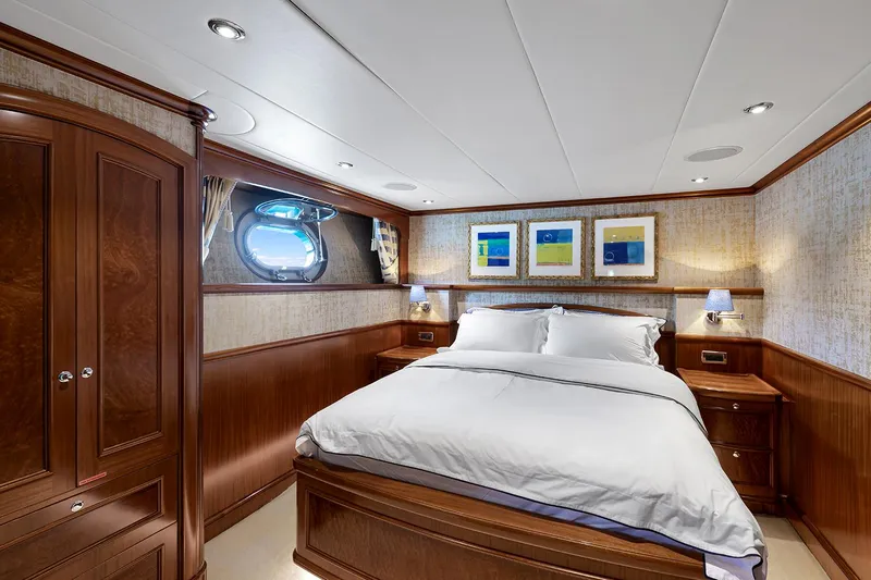  Yacht Photos Pics Luxurious Sovereign Tri-Deck 2003 yacht bedroom with wood paneling and elegant decor.