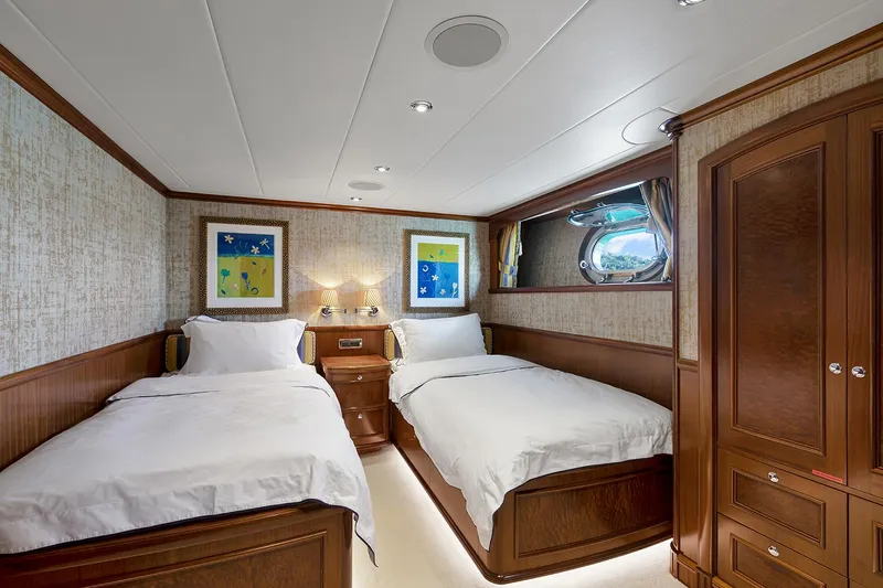  Yacht Photos Pics Luxurious twin cabin on 2003 Sovereign Tri-Deck yacht with elegant wood finishes and porthole window.