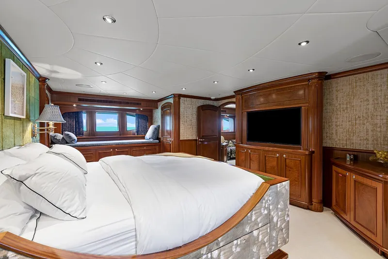  Yacht Photos Pics Luxurious Sovereign Tri-Deck 2003 yacht bedroom with elegant wood furnishings and large bed.