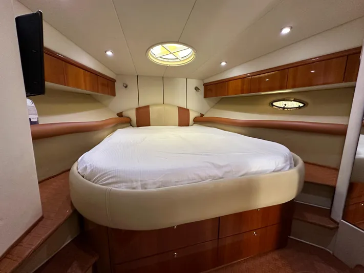  Yacht Photos Pics Luxurious cabin interior of 2001 Sunseeker 44 Camargue yacht with cozy bed and elegant wood finish.