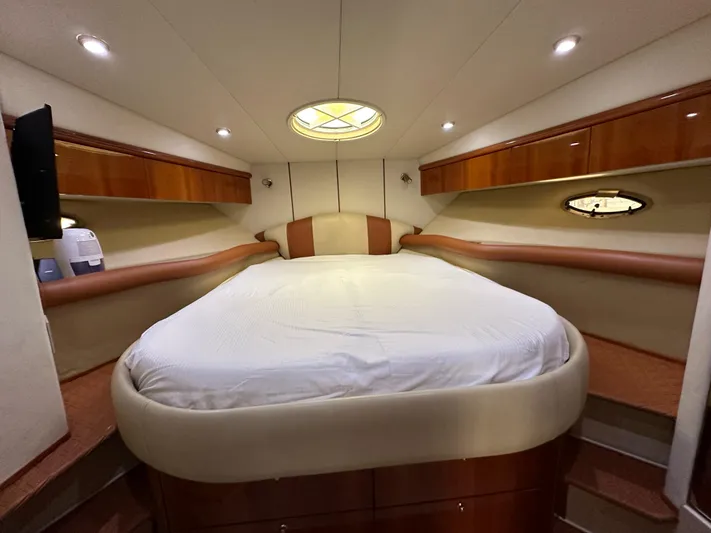  Yacht Photos Pics Luxurious cabin interior of 2001 Sunseeker 44 Camargue yacht with cozy bed and elegant wood finish.