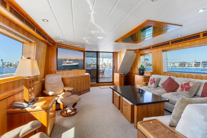 Reverie Yacht Photos Pics Luxurious yacht interior with plush seating, wooden accents, and large windows overlooking the water.