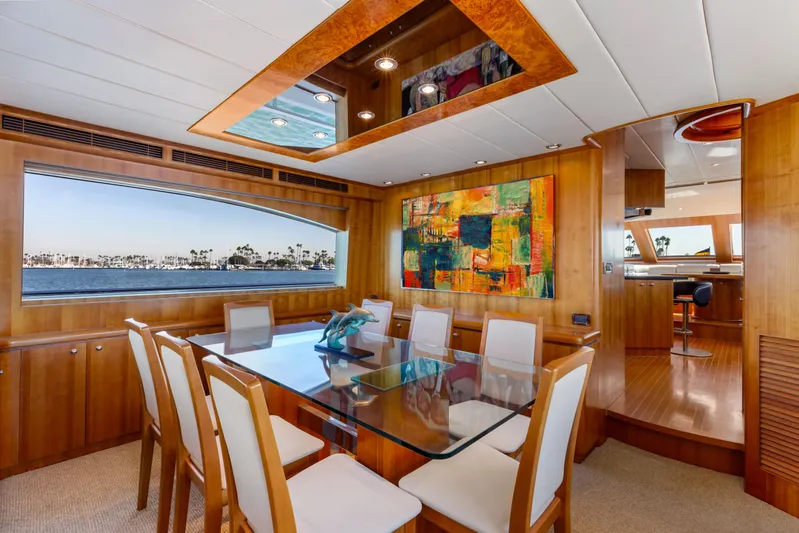 Reverie Yacht Photos Pics Luxurious yacht dining area with glass table, abstract art, and ocean view, 2005 Custom model.