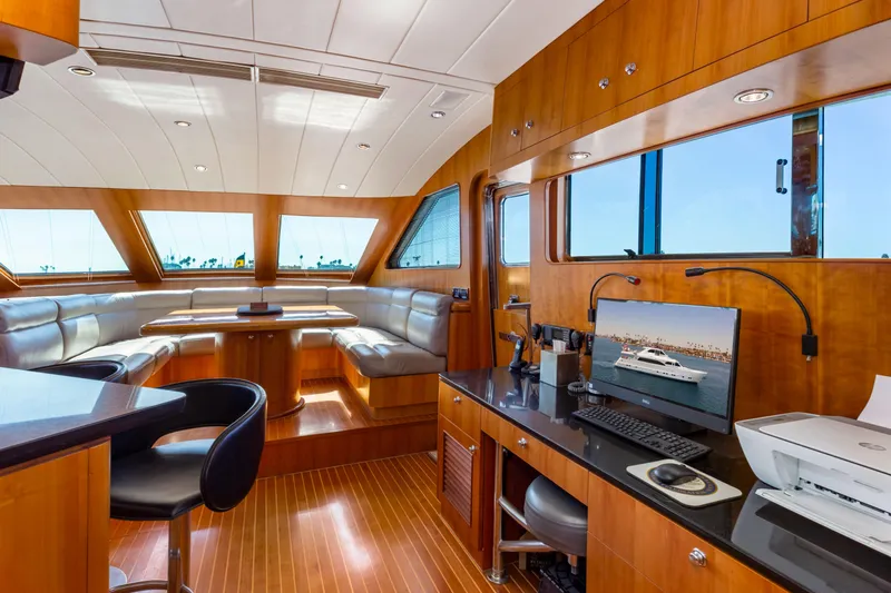 Reverie Yacht Photos Pics Luxurious yacht interior with wood paneling, modern seating, and office setup, 2005 Custom model.