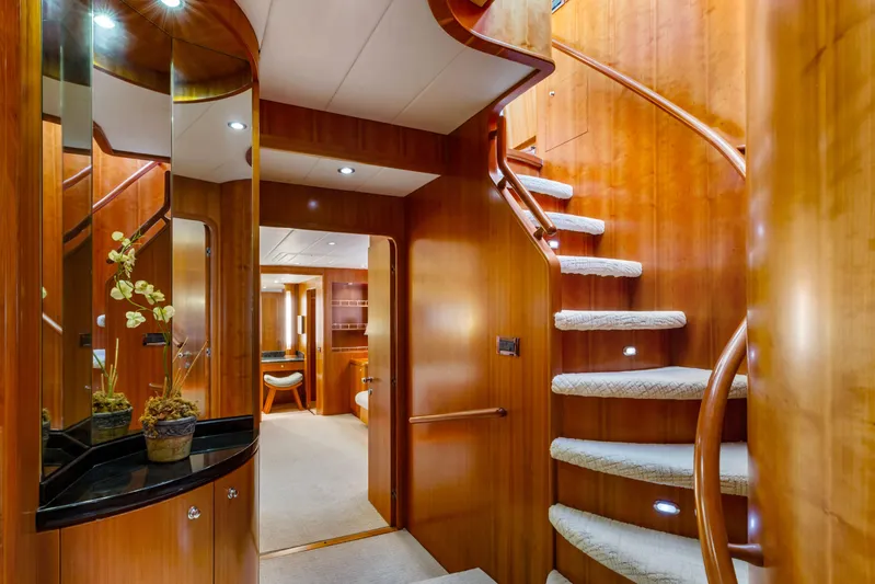 Reverie Yacht Photos Pics Luxurious wooden yacht interior with spiral staircase, elegant decor, and modern lighting, 2005 Custom model.