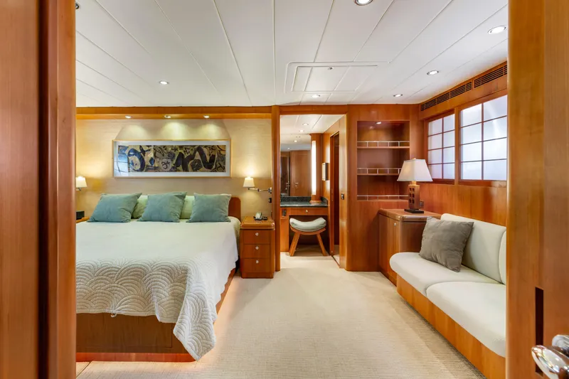 Reverie Yacht Photos Pics Luxurious yacht bedroom with wooden decor, cozy bed, and elegant seating area, 2005 Custom model.