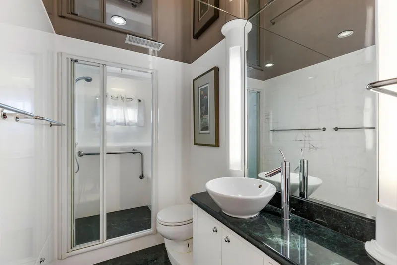 Reverie Yacht Photos Pics Modern bathroom with glass shower, vessel sink, and black countertop, featuring sleek design elements.