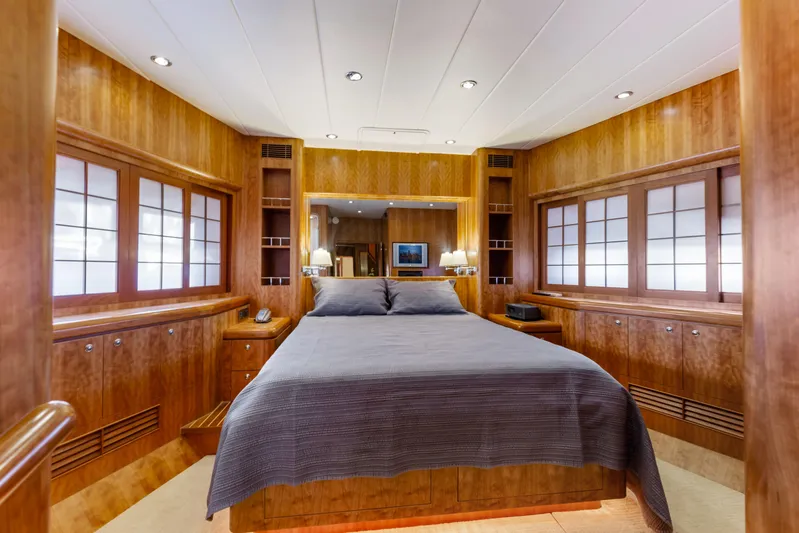 Reverie Yacht Photos Pics Luxurious wooden yacht bedroom interior with double bed, ambient lighting, and elegant cabinetry, 2005 Custom model.