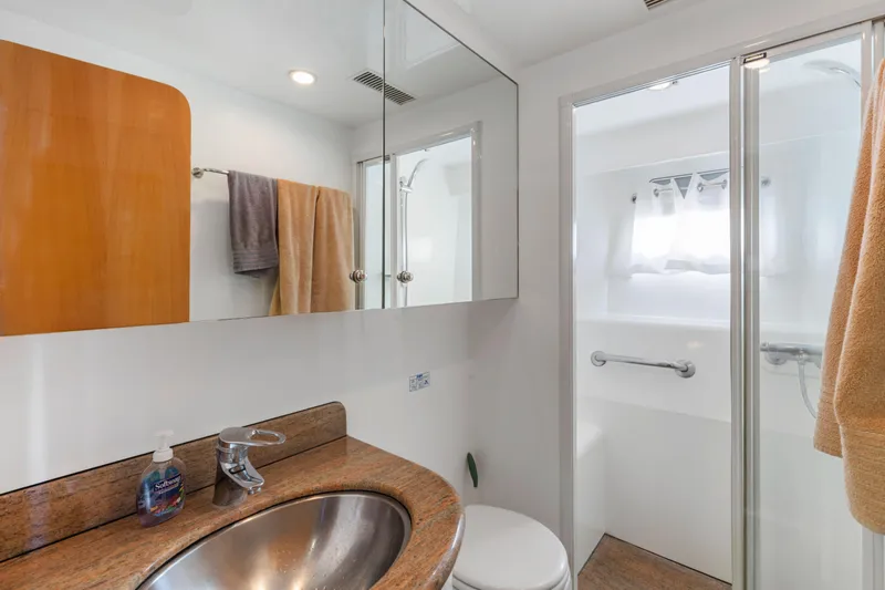 Reverie Yacht Photos Pics Modern bathroom with granite countertop, stainless steel sink, and glass shower in a 2005 Custom model.