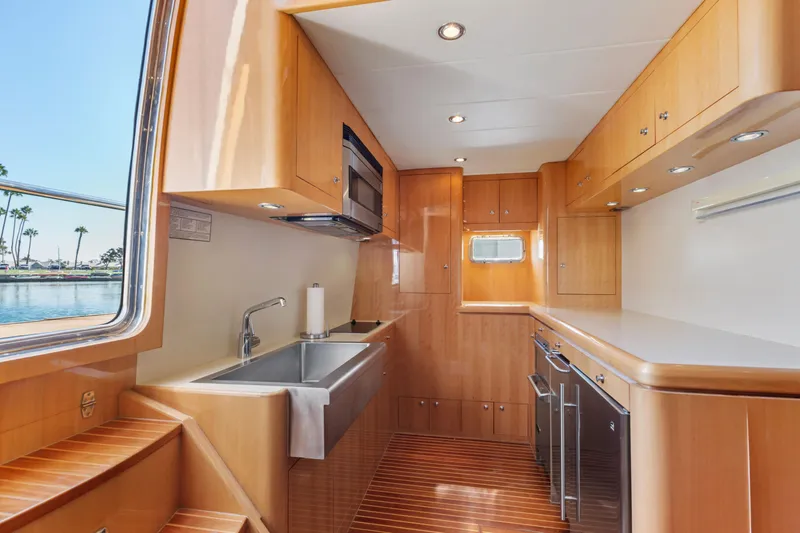 Reverie Yacht Photos Pics Luxurious yacht kitchen interior with wooden cabinetry and modern appliances, 2005 C Custom model.