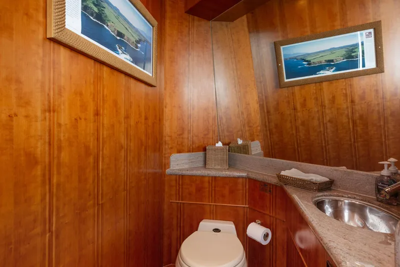 Reverie Yacht Photos Pics Luxurious wooden bathroom with granite countertop, framed coastal artwork, and modern fixtures, 2005 Custom model.