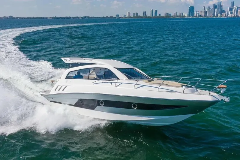  Yacht Photos Pics Luxury Hanover 375 yacht cruising on open water, city skyline in background, 2025 model.