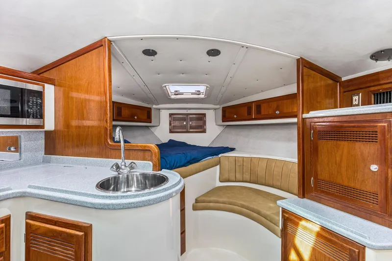 2017 Cummins 540s And Major Re-fit Throughout Yacht Photos Pics Interior of 1995 Cabo 35 Express boat with kitchenette and sleeping area.