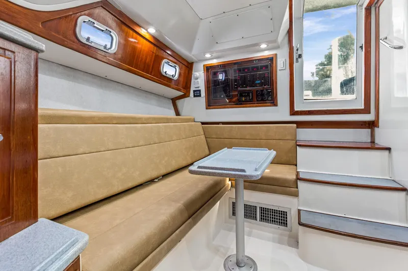 2017 Cummins 540s And Major Re-fit Throughout Yacht Photos Pics Interior of 1995 Cabo 35 Express boat with beige seating and wooden accents.