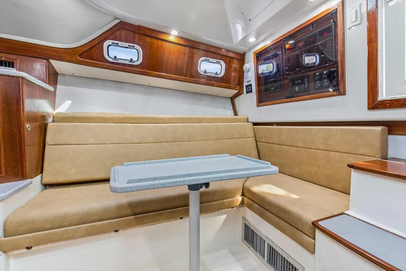2017 Cummins 540s And Major Re-fit Throughout Yacht Photos Pics Interior of 1995 Cabo 35 Express boat with beige seating and control panel.