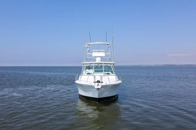 2017 Cummins 540s And Major Re-fit Throughout Yacht Photos Pics 1995 Cabo 35 Express boat on calm ocean under clear blue sky.