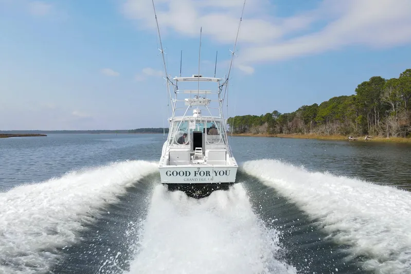2017 Cummins 540s And Major Re-fit Throughout Yacht Photos Pics 1995 Cabo 35 Express boat cruising on a scenic waterway, leaving a wake behind.