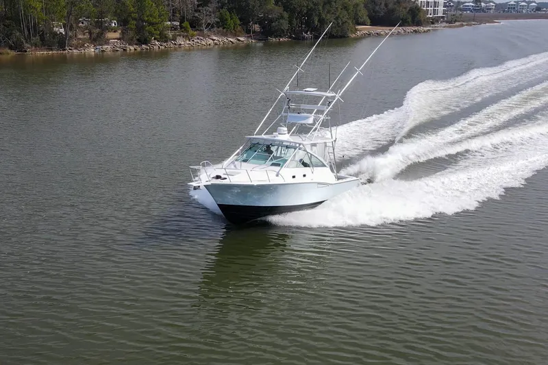 2017 Cummins 540s And Major Re-fit Throughout Yacht Photos Pics 1995 Cabo 35 Express boat cruising on a calm river, surrounded by trees.