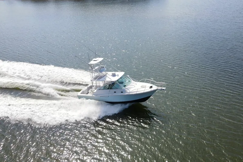2017 Cummins 540s And Major Re-fit Throughout Yacht Photos Pics A 1995 Cabo 35 Express boat cruising swiftly on open water.