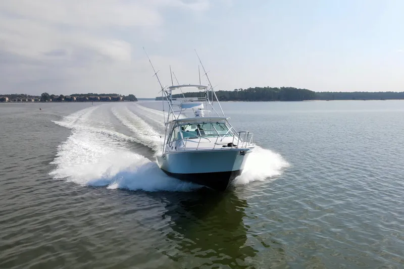 2017 Cummins 540s And Major Re-fit Throughout Yacht Photos Pics 1995 Cabo 35 Express boat cruising on a calm lake, leaving a wake behind.