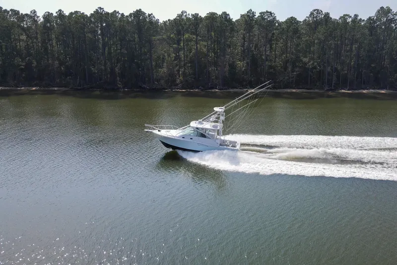 2017 Cummins 540s And Major Re-fit Throughout Yacht Photos Pics 1995 Cabo 35 Express boat cruising on a calm river with forested shoreline.