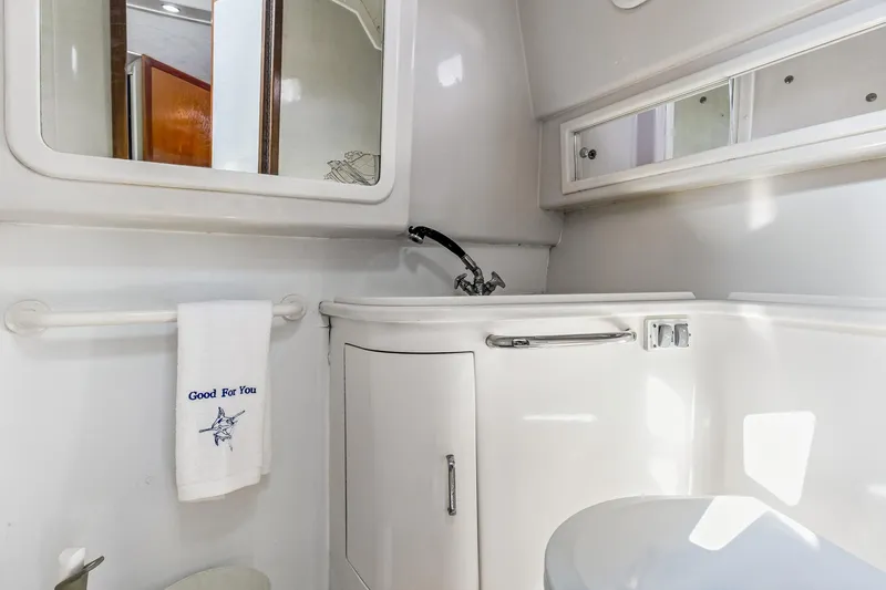 2017 Cummins 540s And Major Re-fit Throughout Yacht Photos Pics Bathroom interior of 1995 Cabo 35 Express yacht, featuring sink, mirror, and towel.
