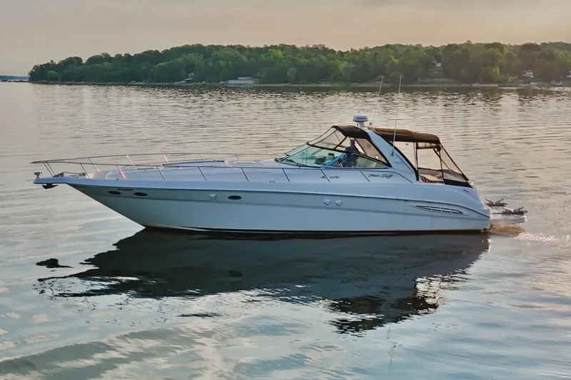Empty Pockets Yacht Photos Pics 1999 Sea Ray 460 Sundancer yacht cruising on calm water at sunset.