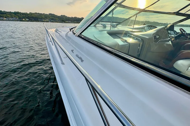 Empty Pockets Yacht Photos Pics 1999 Sea Ray 460 Sundancer yacht cruising on a serene lake at sunset.