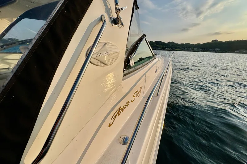 Empty Pockets Yacht Photos Pics 1999 Sea Ray 460 Sundancer yacht on calm water at sunset.