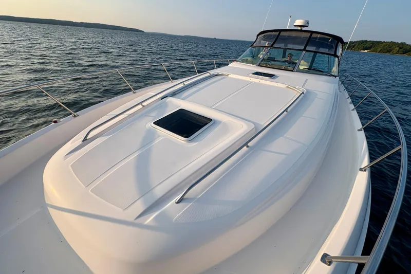 Empty Pockets Yacht Photos Pics 1999 Sea Ray 460 Sundancer yacht cruising on a serene lake.