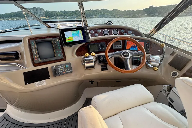 Empty Pockets Yacht Photos Pics 1999 Sea Ray 460 Sundancer helm with navigation equipment and wooden steering wheel.