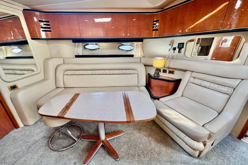 Empty Pockets Yacht Photos Pics Luxurious interior of 1999 Sea Ray 460 Sundancer yacht with plush seating and elegant table.